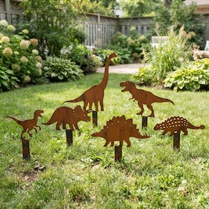Könnte beinhalten: Ein Set aus fünf rostfarbenen Metalldinosaurier-Silhouetten als Gartenstecker. Die Sammlung umfasst einen großen Sauropoden mit langem Hals, einen zweibeinigen Theropoden, einen Triceratops, einen Stegosaurus und einen Ankylosaurus auf Metallstäben.