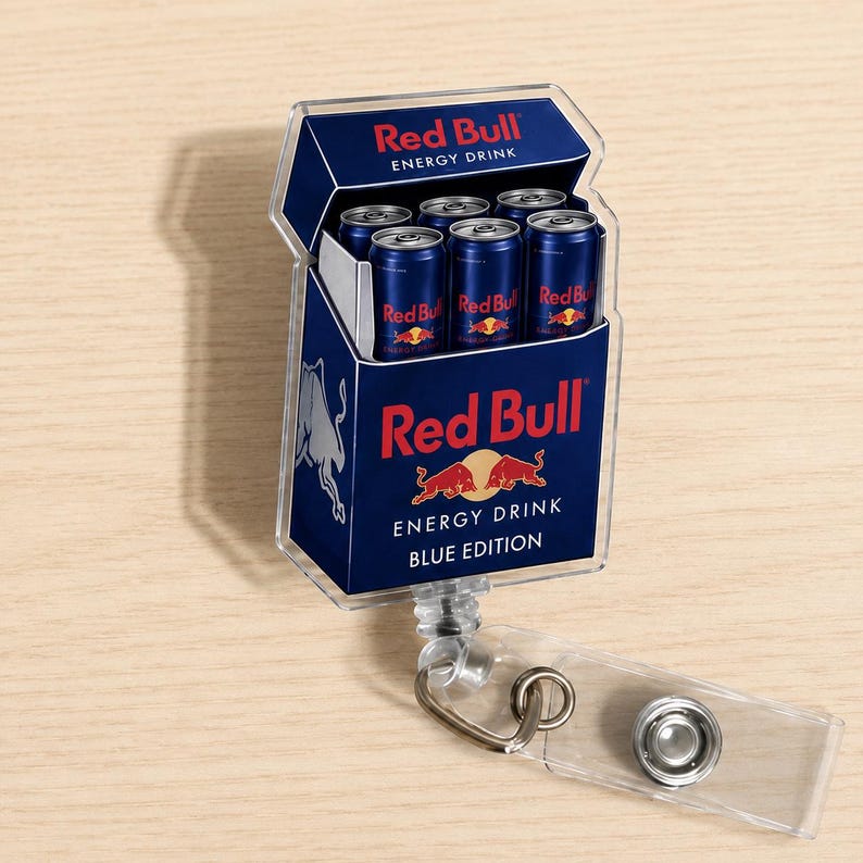 K&ouml;nnte beinhalten: Ein rechteckiger Ausweishalter aus Acryl mit einer Grafik einer Red Bull Energy-Drink-Packung. Das Design zeigt das blau-silberne Branding, das Red Bull-Logo und den Text Red Bull Energy Drink Blue Edition mit sechs Miniaturdosen.