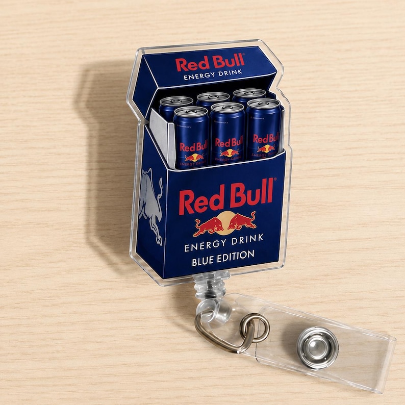 K&ouml;nnte beinhalten: Ein rechteckiger Ausweishalter aus Acryl mit einer Grafik einer Red Bull Energy-Drink-Packung. Das Design zeigt das blau-silberne Branding, das Red Bull-Logo und den Text Red Bull Energy Drink Blue Edition mit sechs Miniaturdosen.