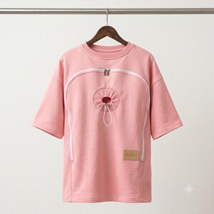 Pink cat carrier shirt flat lay showing heart-shaped zip pouch and side pocket