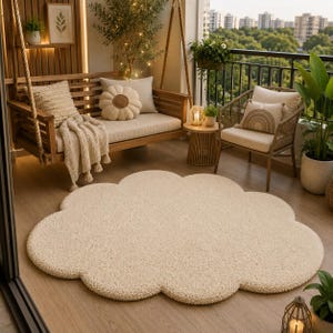 May include: A large, cream-colored, cloud-shaped area rug with a textured, tufted surface. The rug is positioned on a wooden floor in an outdoor balcony space, featuring a wooden hanging bench, a wicker chair, and various potted plants.