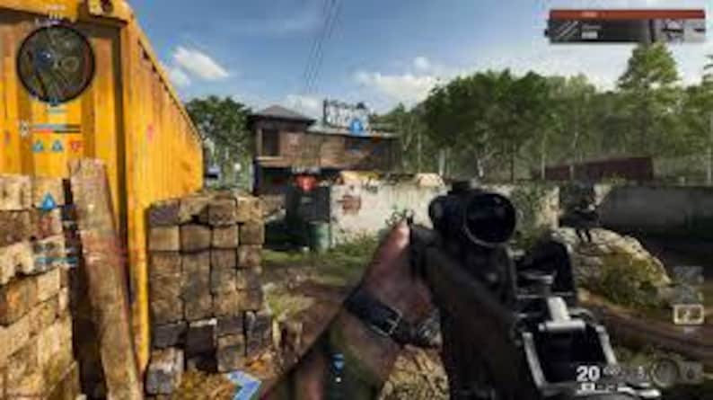 May include: First-person view of a rifle with a scope, held by a person in a camouflage sleeve. The scene is set outdoors, with a yellow container and a building in the background. The sky is blue with some clouds.