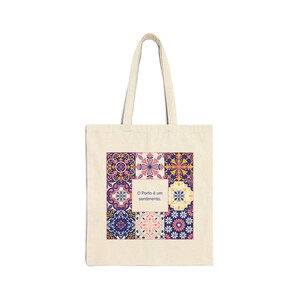 Pode incluir: Saco tote creme com um design de azulejos coloridos. O design inclui vários padrões florais e geométricos em tons de rosa, azul, amarelo e branco. O texto "O Porto é um sentimento" está centrado.