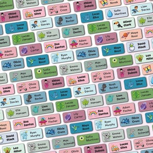 May include: A collection of rectangular adhesive labels in various pastel colours, each featuring a unique cartoon illustration and a printed name. The designs include animals, vehicles, plants, and space themes, with the Graphico logo at the top.