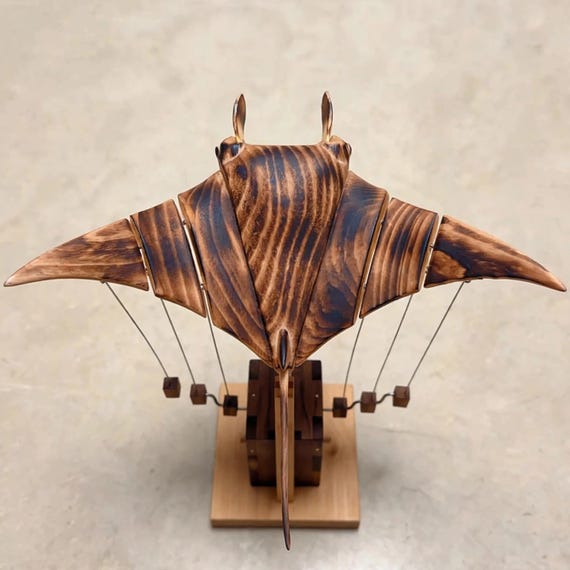 A hand-carved wooden manta ray that actually 'flies' through mechanical motion — kinetic desk art that doubles as a conversation-stopping sculpture.