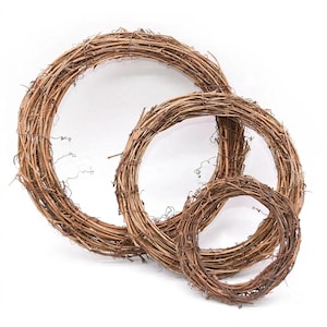 May include: Three circular wreaths constructed from natural brown intertwined twigs and vines. The wreaths are arranged in a nested formation, featuring one large, one medium, and one small ring, each with a textured, rustic, and organic appearance.