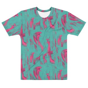 以下が含まれることがあります： ピンクのコブラのイラストが繰り返される模様のターコイズ色のTシャツ。コブラのデザインは様式化されており、テクスチャ加工が施されているように見えます。Tシャツはクルーネックで半袖です。