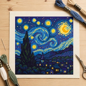 May include: A square cross-stitch embroidery project depicting a night sky with a large yellow moon, swirling blue clouds, and a dark cypress tree silhouette over a village. Includes blue, green, and cream embroidery floss, a needle, and scissors.