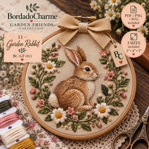 Op de afbeelding: Een borduurring met een bruin konijn omringd door een krans van witte madeliefjes en roze bloemen. De ring is afgewerkt met een beige jute strik en een BC-label. Tekst: BordadoCharme Garden Friends Collection 11 Garden Rabbit.