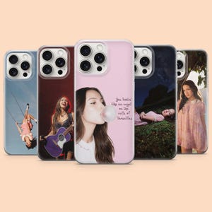 May include: Five smartphone cases featuring photographic prints of a person. One case shows a person on a swing, another playing a purple guitar, one with a person blowing a bubble with text reading You lookin' like an angel on the walls of Versailles.