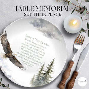 May include: A white ceramic plate featuring a watercolor illustration of a bald eagle in flight, pine trees, and clouds. The text reads: Reserved for Grandpa, a poem, and ALWAYS REMEMBERED, FOREVER LOVED. A fork and knife with wooden handles are nearby.