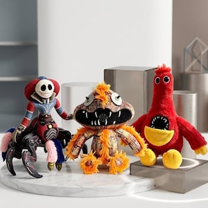 May include: Three plush monster toys. One is a red, blue, and black spider-like creature with a skull face. The second is an orange and brown monster with a toothy grin. The third is a red bird-like monster with a yellow beak and feet.