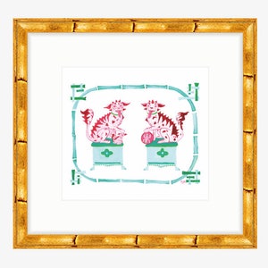 May include: A framed print depicting two pink and red mythical creatures with green and blue accents. The creatures are seated on pedestals with a green bamboo design surrounding them.