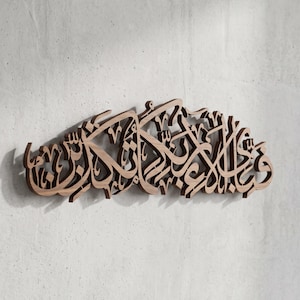 Puede incluir: Una pieza decorativa de madera para pared que presenta una intrincada caligrafía árabe cortada con láser. Se aprecia la veta de la madera marrón natural y la compleja escritura fluida crea un efecto tridimensional con sombras proyectadas.