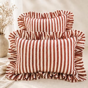 Può includere: Due cuscini rettangolari caratterizzati da un motivo a righe verticali color rosso ruggine e bianco sporco. Ogni cuscino è rifinito con un bordo a volant arricciato su tutti e quattro i lati, realizzato in tessuto testurizzato.