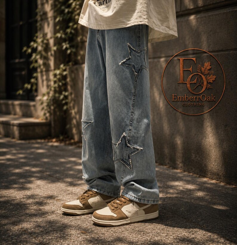 May include: Light blue denim jeans featuring star-shaped cutouts on the knees and thighs. The jeans are worn with brown and cream-coloured trainers. The image is taken outside, with a neutral backdrop.