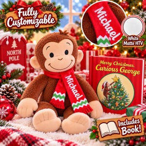 May include: A brown plush monkey toy wearing a red scarf with the name Michael and a green and white chevron pattern. Beside the monkey is a hardcover book titled Merry Christmas, Curious George, featuring an illustration of the monkey decorating a tree.