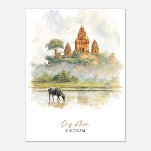 May include: Watercolor print of Quy Nhon, Vietnam. The artwork depicts ancient temples atop a hill, lush greenery, and a water buffalo in a serene landscape. The print has a soft, artistic style with the text "Quy Nhon, Vietnam" at the bottom.