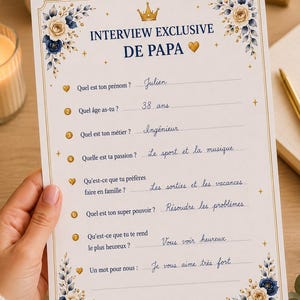 Peut inclure: Un questionnaire en papier blanc intitulé INTERVIEW EXCLUSIVE DE PAPA avec une couronne dorée et un cœur. Le document présente des coins fleuris en bleu et crème, des questions numérotées de un à huit et des réponses manuscrites à l'encre bleue.