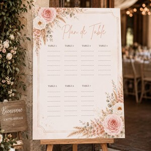 Peut inclure: Un panneau de plan de table rectangulaire sur un chevalet en bois avec le texte Plan de Table. Le panneau présente un fond crème, une bordure décorative et des illustrations florales de roses roses, fleurs blanches et herbes de la pampa.