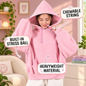 May include: A light pink hooded sweatshirt featuring a drawstring with a chewable tip, a built-in stress ball, and a kangaroo pocket. The garment is made of a heavyweight material. Text on the image includes CHEWABLE STRING, BUILT-IN STRESS BALL, and HEAVYWEIGHT MATERIAL.