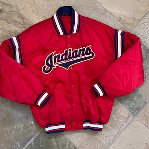 Könnte beinhalten: Rote Satinjacke mit dem Wort "Indians" in weißer Schrift auf der Brust. Die Jacke hat weiße Streifen auf den Ärmeln und um den Kragen, die Manschetten und die Taille. Die Jacke ist zugeknöpft.