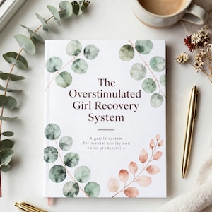 Può includere: Un libro bianco intitolato "The Overstimulated Girl Recovery System" con illustrazioni botaniche verdi e pesca. Una penna d'oro e una tazza di caffè sono accanto al libro. Il sottotitolo recita: "A gentle system for mental clarity and calm productivity."