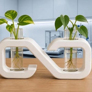 May include: A white infinity-shaped propagation station featuring two clear glass test tubes. Each tube holds a green plant cutting with visible roots submerged in water. The structure is smooth and matte, designed to hold the glass vessels upright.