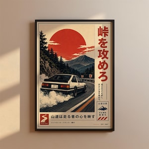 May include: A framed poster featuring a white and black hatchback car drifting on a mountain road. The scene includes a large red sun, pine trees, and a mountain peak. Japanese text is printed vertically and horizontally on the right and bottom.