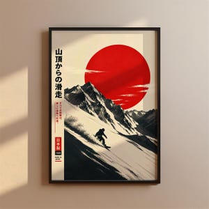 May include: A framed wall art print featuring a snowboarder descending a snow-covered mountain slope under a large red sun. The design includes Japanese text, the phrase 'MADE IN JAPAN', and the year 1989, set against a cream-coloured background.