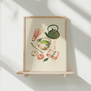 May include: A framed art print featuring a green cast iron teapot, a bamboo whisk, a bowl of matcha, a bamboo scoop, two small round confections, a folded cloth, and a green leaf. The Japanese text 抹茶の時間 is printed in red ink.