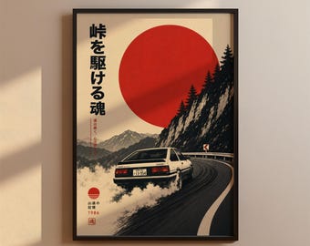 Może przedstawiać: Oprawiony pionowy plakat przedstawiający biały samochód sportowy driftujący na krętej górskiej drodze. Duże czerwone koło znajduje się w tle nad ciemnymi sosnami i górami. Nadrukowany japoński tekst oraz rok 1986.