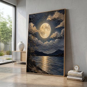 May include: A rectangular framed oil painting featuring a textured impasto night landscape. A large, luminous yellow moon hangs in a dark blue sky filled with thick clouds above a calm lake. The moonlight reflects on the water, illuminating the dark shoreline.