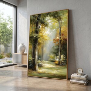 Puede incluir: Pintura de paisaje enmarcada que representa una escena de bosque soleado. La obra presenta árboles altos con follaje verde y amarillo, un camino que conduce a la distancia y una paleta de colores cálidos y naturales. El marco es de color marrón claro.