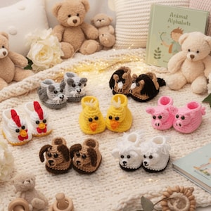Può includere: Una collezione di sei paia di scarpine per neonati realizzate a mano all'uncinetto, raffiguranti vari animali come pollo, anatra, maiale, cane, pecora e cavallo, disposte su una coperta in maglia bianca con diversi orsacchiotti di peluche.