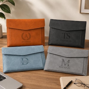 May include: Four rectangular document folders with envelope-style flaps in orange, black, light blue, and gray. Each folder features a custom laser-engraved monogram and name: Anthony with a laurel wreath, TS Thomas, D Daniel, and M Michael.