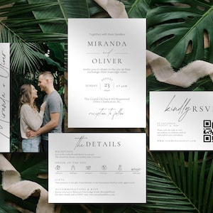 May include: Wedding invitation suite featuring a photo of a couple, with additional cards for details and RSVP. The suite includes the names "Miranda and Oliver" in elegant script, set against a backdrop of lush green foliage and a neutral ribbon.