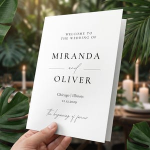 May include: A white wedding program with black text. The program reads "WELCOME TO THE WEDDING OF MIRANDA and OLIVER Chicago | Illinois 12.12.2029 The beginning of forever."