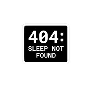 May include: A rectangular black sticker with rounded corners featuring white text that reads 404: SLEEP NOT FOUND. The font is a bold, sans-serif style with a pixelated or digital appearance, centered on the dark background.