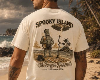 Könnte beinhalten: Ein cremefarbenes Kurzarm-T-Shirt mit einem Grafikdruck auf der Rückseite. Das Motiv zeigt ein Monster am Strand mit dem Text "SPOOKY ISLAND", "Voltage Beach" und "est. Halloween 1986" sowie einem Blitz und Palmen.