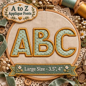 Puede incluir: Un bastidor de bordado con tela que muestra las letras A, B y C cosidas en verde claro con lunares dorados y bordes dorados. Una etiqueta dice A to Z Applique Fonts y una cinta muestra Large Size - 8,9 cm, 10,2 cm.