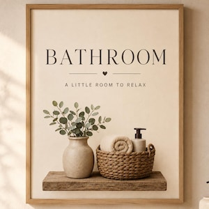 May include: A framed wall art print featuring the text BATHROOM and A LITTLE ROOM TO RELAX with a small heart icon. The print displays a wooden shelf holding a beige vase with green eucalyptus leaves and a woven basket containing a rolled towel.