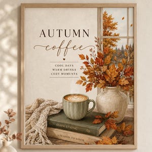 Op de afbeelding: Een ingelijste wandprint met een groene koffiemok op gestapelde boeken, een beige gebreide deken en een vaas met herfstbladeren bij een raam. De tekst luidt: AUTUMN coffee, COOL DAYS, WARM DRINKS, COZY MOMENTS, SLOW LIVING, A SEASON TO SAVOR.