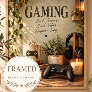 May include: A framed wall art piece featuring the text GAMING, Good Games, Good Vibes, Happier Days. The image displays a mug with a game controller graphic, a potted plant, black headphones, a game controller, and a lit candle in a glass jar.