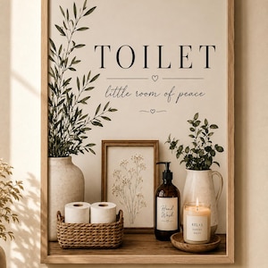 Pode incluir: Uma impressão de parede emoldurada com o texto TOILET little room of peace e ícones de coração. A imagem exibe uma cesta trançada com dois rolos de papel higiênico, um frasco de sabonete líquido de vidro marrom, uma vela e dois vasos.