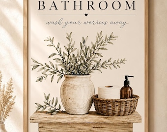 以下が含まれることがあります： BATHROOMとwash your worries awayという文字と小さなハートが描かれた額入りアートプリント。素朴な木製の棚に、緑の枝が入った陶器の花瓶、トイレットペーパー、茶色のボトルが置かれている様子が描かれています。