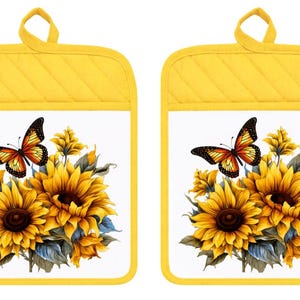 May include: A pair of rectangular pot holders with bright yellow quilted borders and hanging loops. The center of each features a white background printed with a vibrant illustration of yellow sunflowers and a monarch butterfly with orange wings.