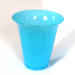 May include: A vibrant, turquoise-colored glass vase with a flared top and a slightly tapered body. The vase is made of a smooth, glossy material and is designed to hold flowers or other decorative items. The vase is approximately 7 inches tall.