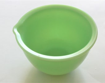 May include: A light green mixing bowl with a pour spout. The bowl is made of glass and has a smooth, glossy finish.