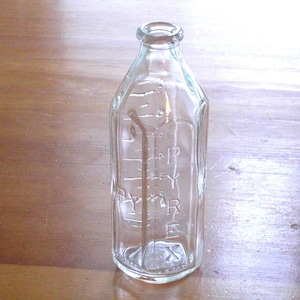 May include: A clear glass baby bottle with a textured surface and markings for measuring liquid. The bottle is labeled "PYREX".